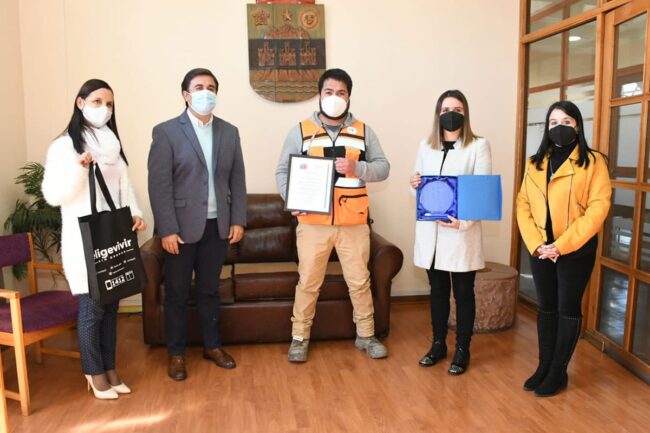 noticia-premio-senda-optim Trabajador con chaleco reflectante recibe reconocimiento junto a autoridades en oficina municipal